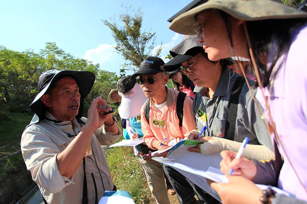 生態解說員李榮芳，為紙教堂的遊客介紹各色飛舞的蝴蝶。